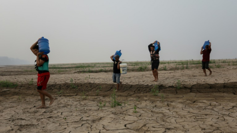 Ribeirinhos presos no leito de um rio que arde devido à seca na Amazônia